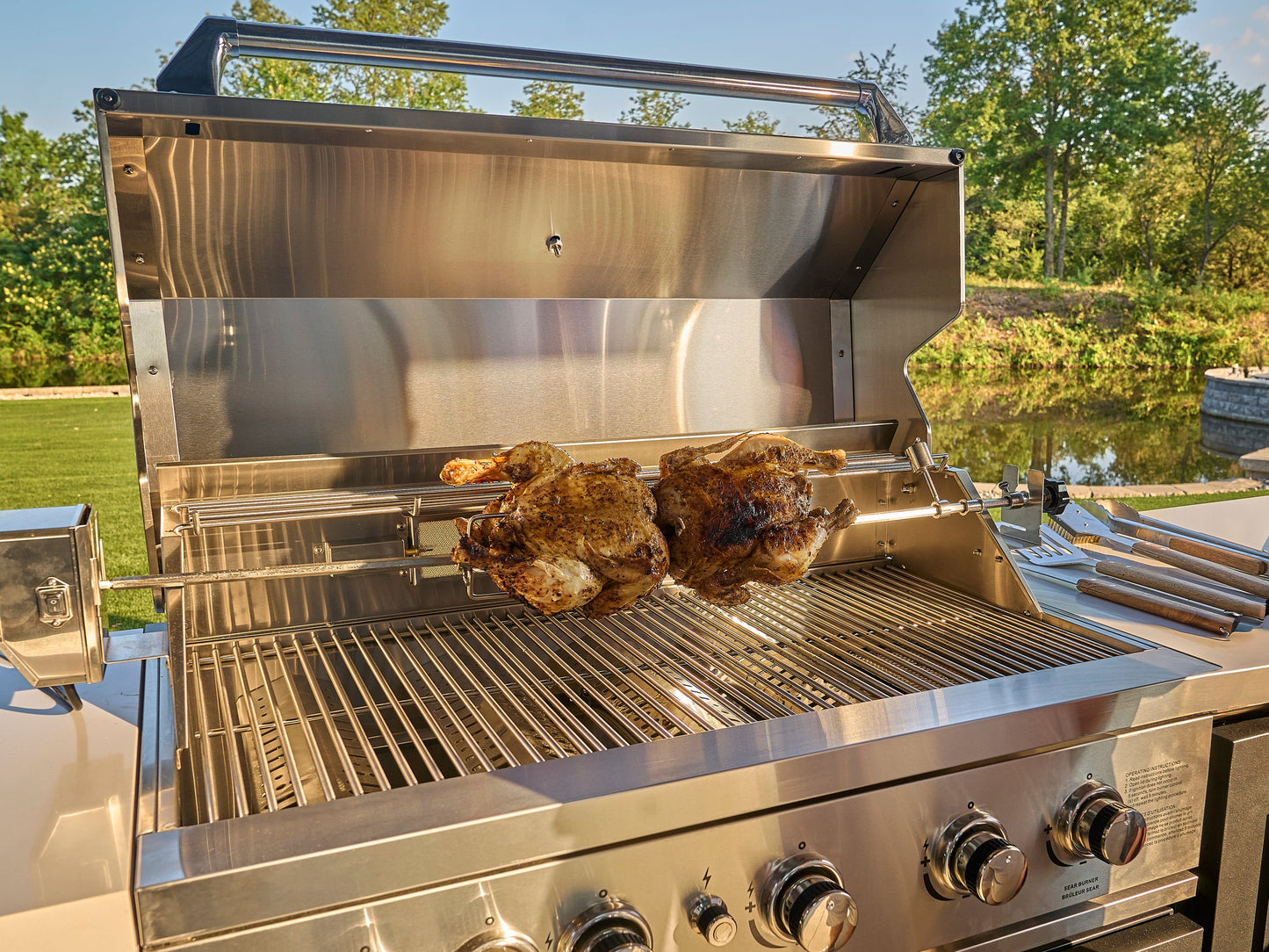 Range Outdoor Living 304 Stainless Steel, 5-burner grill with rotisserie chickens in Edgemont Bay outdoor kitchen.
