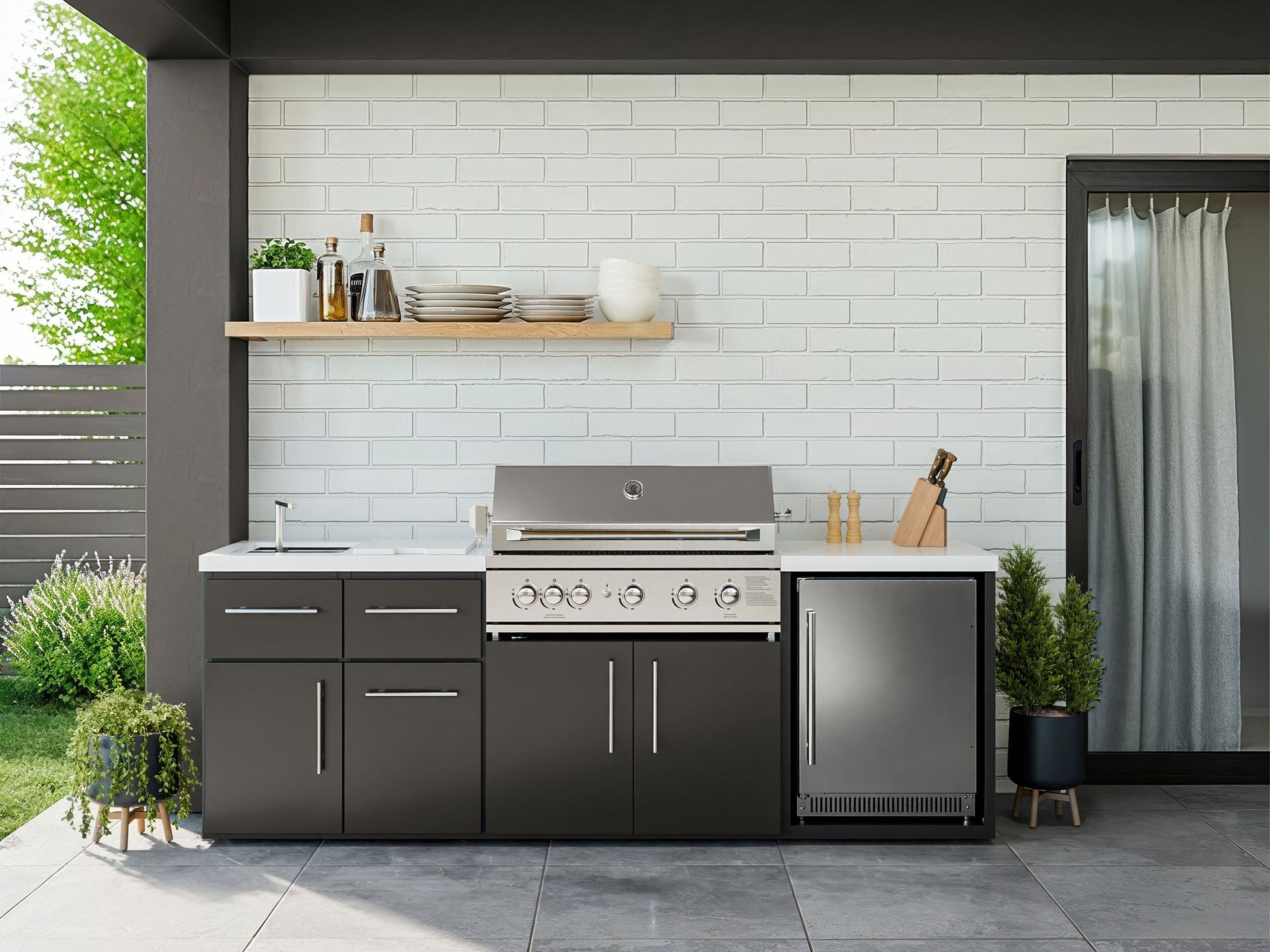Range Outdoor Living Emory kitchen island with grill, refrigerator, storage cabinets and sink on patio.