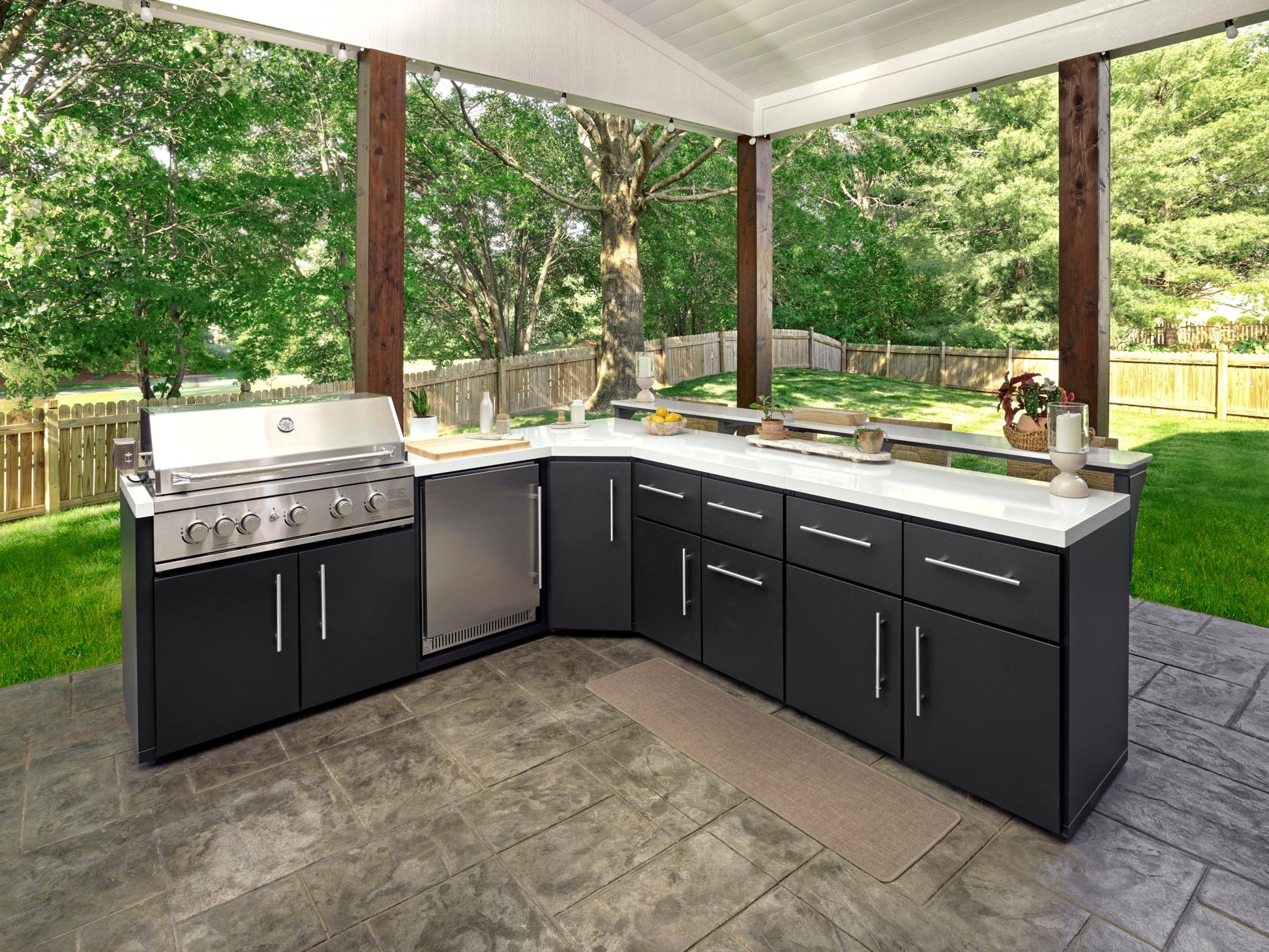 Emory l-shaped outdoor kitchen design with black cabinets, engineered stone countertop.