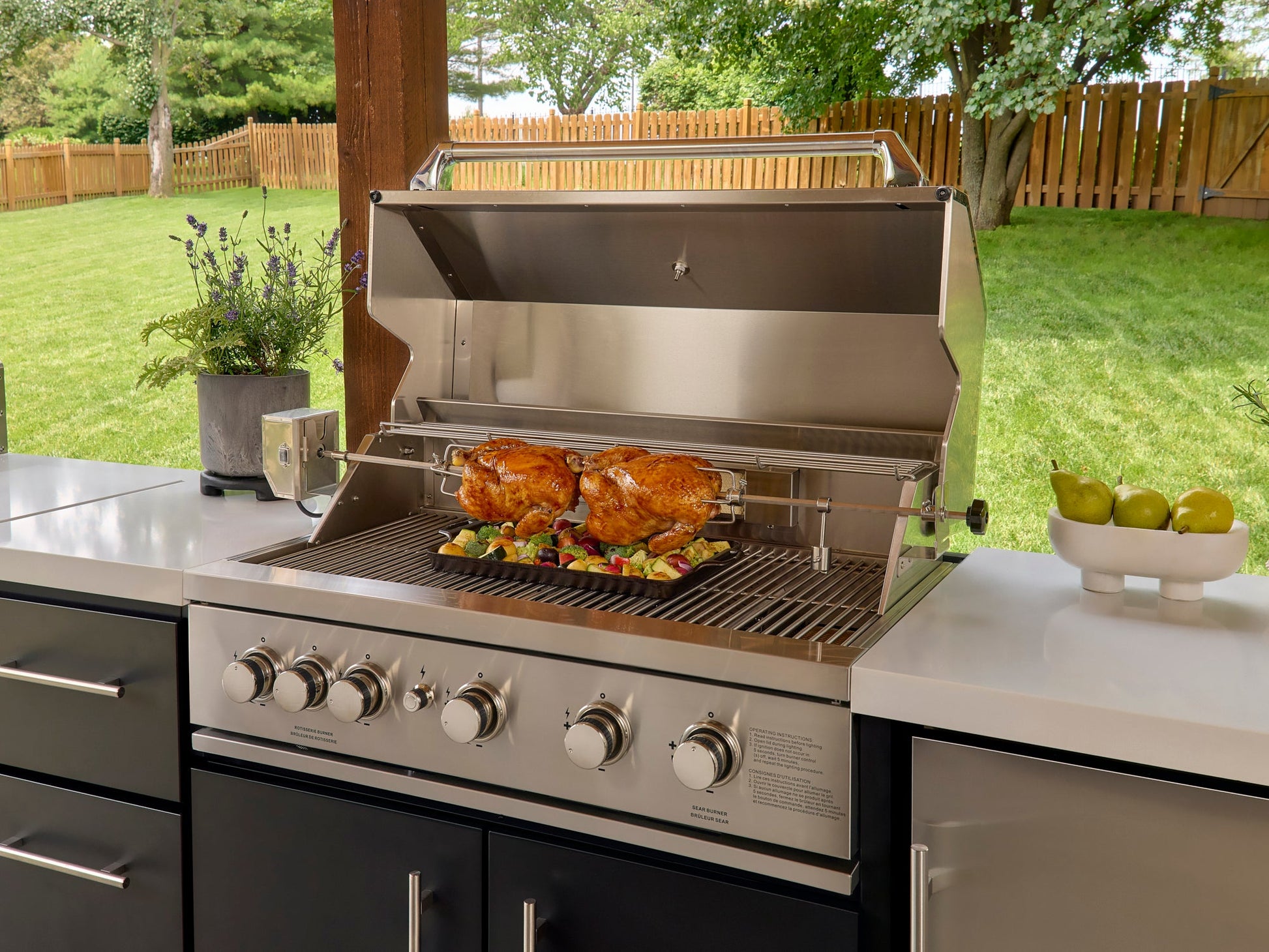 Range Outdoor Living Emory kitchen grill with rotisserie chickens on bbq island with engineered stone countertop.