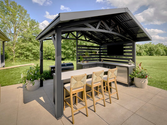 Modern steel roof covering Langston outdoor kitchen with bar seating and grill in spacious backyard setting.