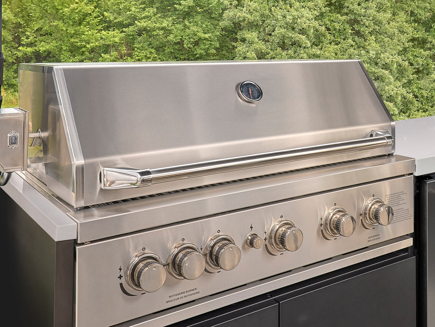 Stainless Emory steel outdoor grill with lid open, temperature gauge, chrome handle, and six control knobs on front panel.