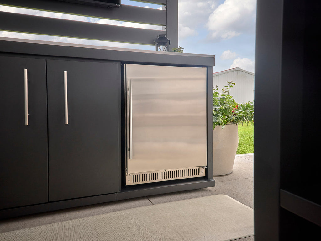 Outdoor beverage refrigerator with stainless steel door installed in Langston outdoor kitchen cabinetry on covered patio.