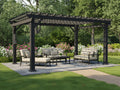 Black steel pergola with trellis roof over outdoor seating area surrounded by flowering garden beds and lush greenery.